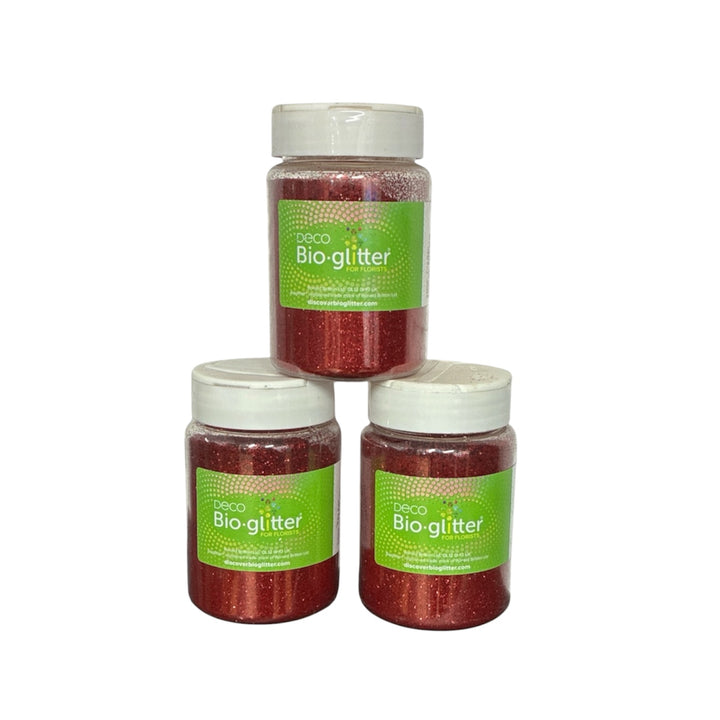 Three clear plastic jars of D2CO Red Bio-glitter in a stacked pyramid arrangement on a plain white background.