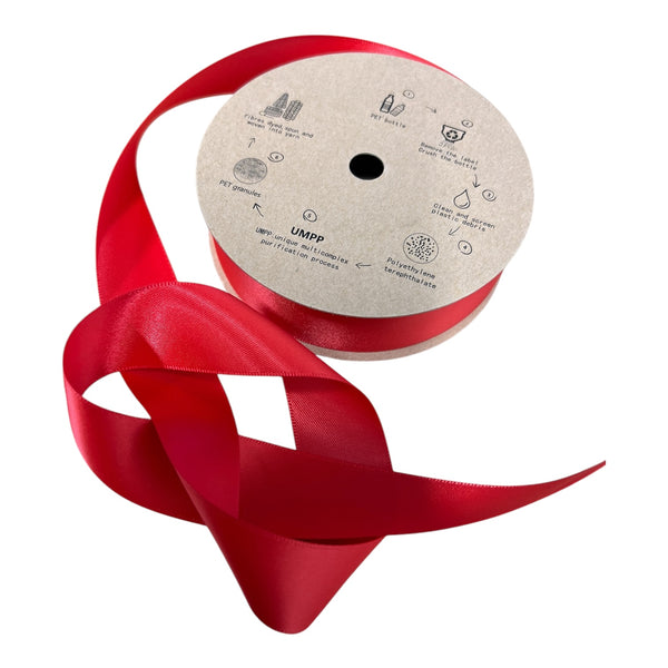 A spool of double faced red satin ribbon, with a label indicating it is made from recycled plastic bottles, and measures 25mm in width.