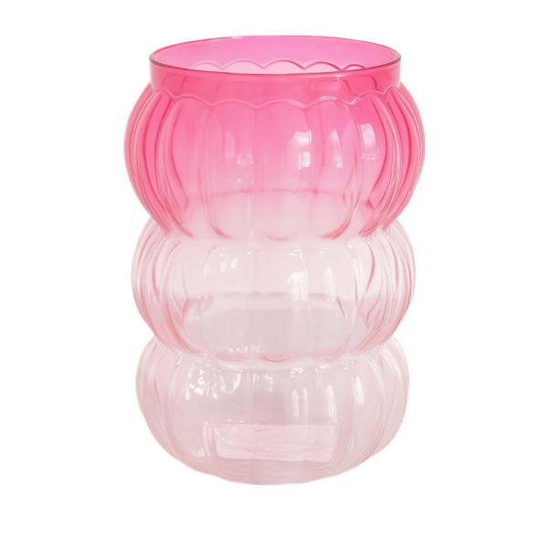 Pink glass vase with ribbed texture on a white background