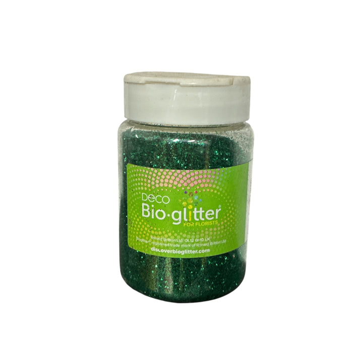 A jar of Deco Bio-glitter in a deep green shade with fine glitter, featuring a green label and a white lid, set against a plain white background.
