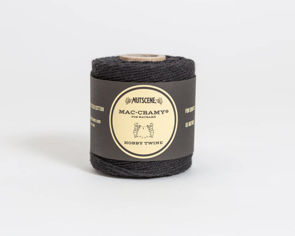 Roll of black twine with a label on a white background