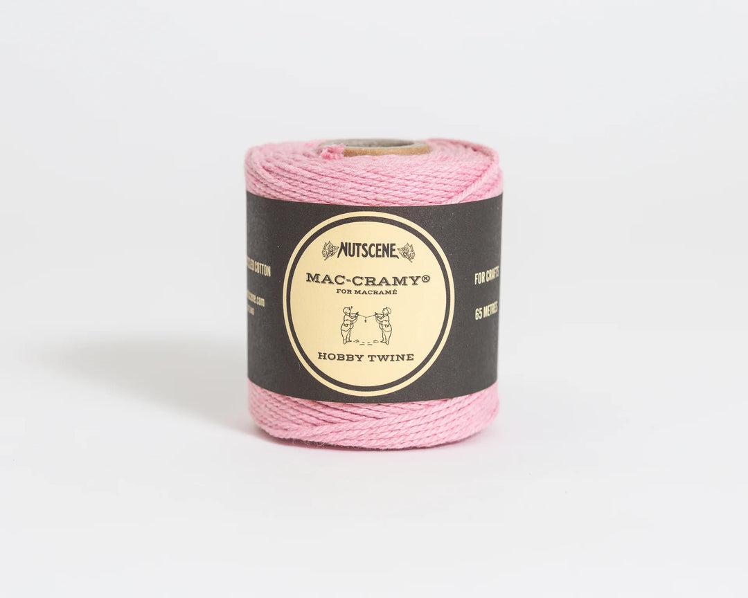 Pink yarn on a black label with &