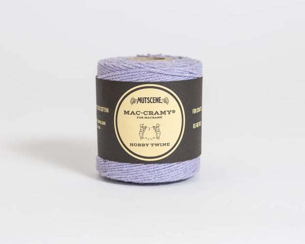 Spool of purple twine with a black label on a light gray background