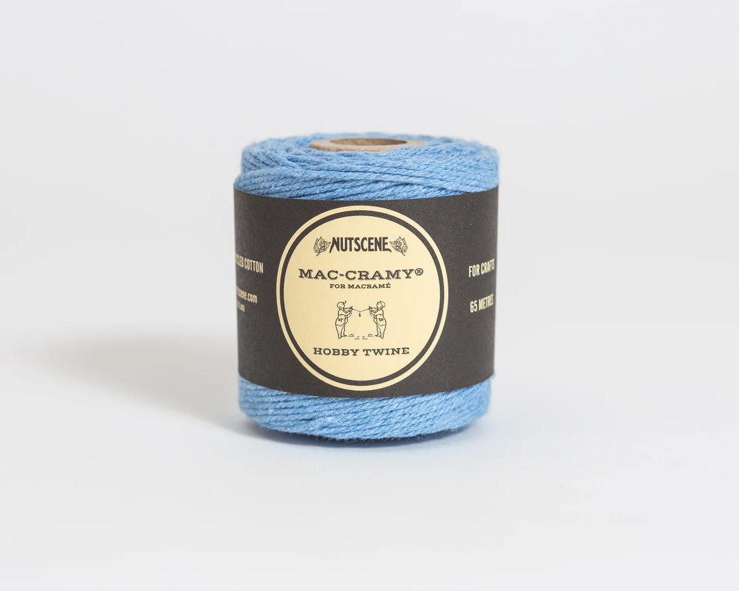 Blue yarn ball with a black label on a white background