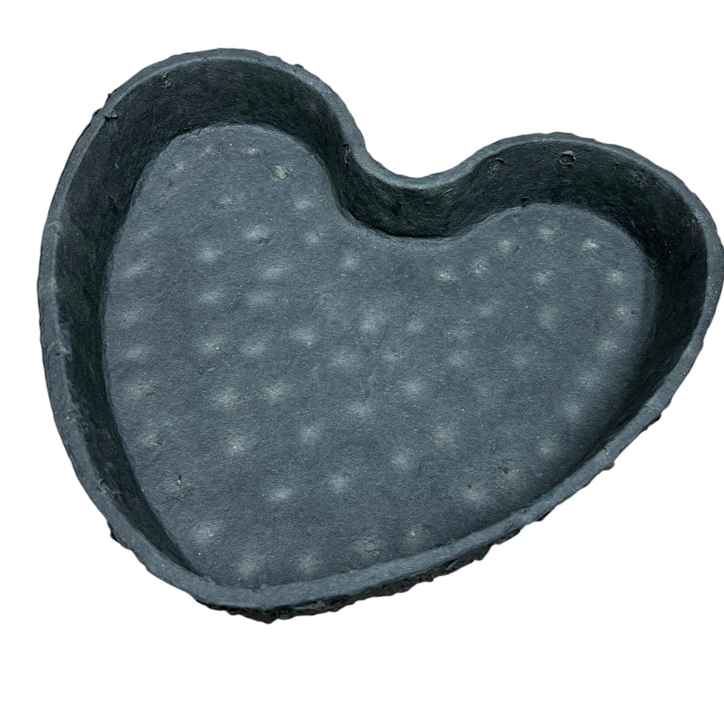 A biodegradable black tray in the shape of a heart, with a natural-looking base texture.