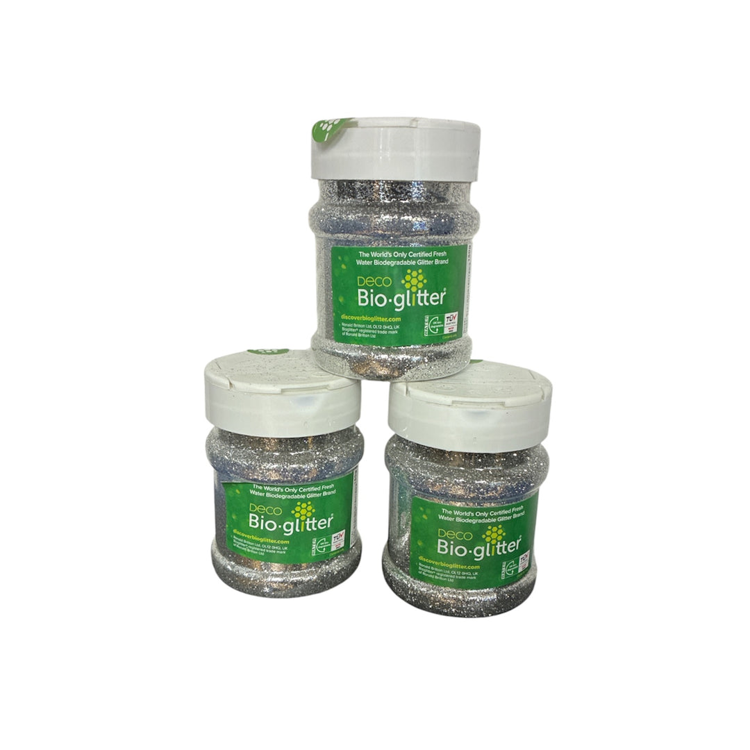 Three jars of Deco Silver Bio-glitter arranged in a pyramid on a plain white background. The jars are filled with silver glitter and feature green labels with white caps.