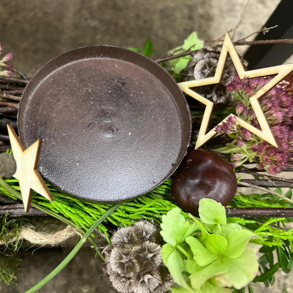 Lightweight natural wooden stars attached to a green festive Christmas wreath as a compostable, rustic decorative accent.