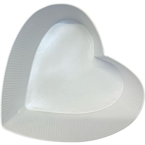 A white ribbed zinc planter in the shape of a heart.