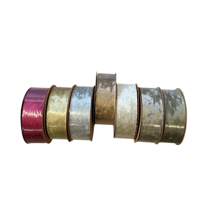Collection ofcrushed velvet ribbons rolls in various colors on a white background