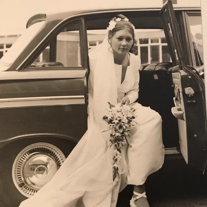 Black and white vintage photograph of Carol stepping out of a wedding car, the inspiration behind the Spinsterz Carol MidiGaunt glove.